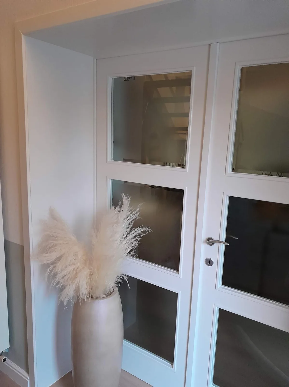 Witte dubbele glasdeur in geschilderde hal