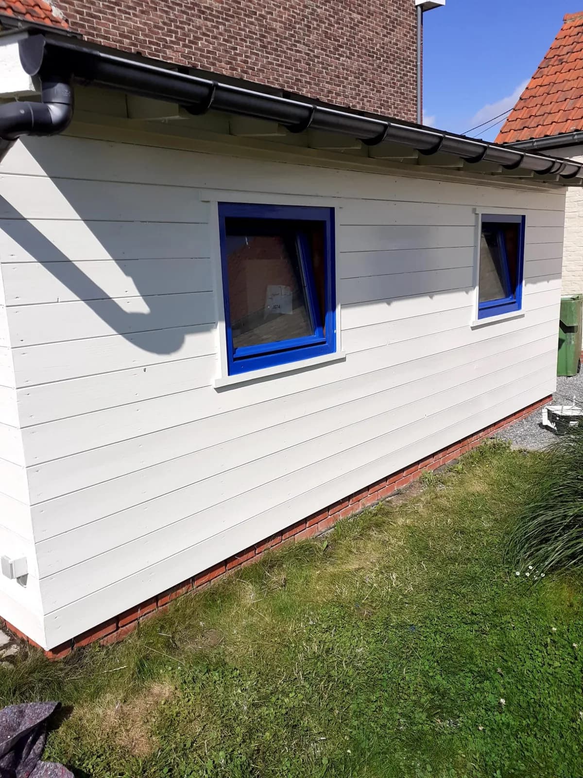 Houten aanbouw wit met blauwe ramen